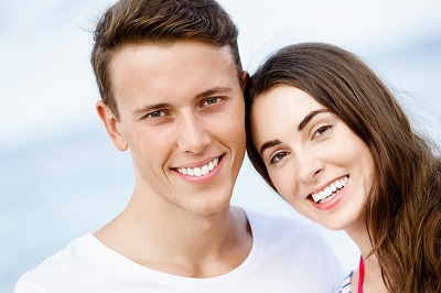 Romantic young couple with white smile on the beach